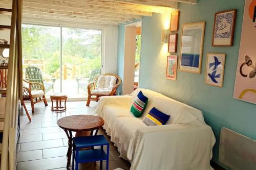 un salon avec un canapé blanc et une table dans l'établissement Charmante maison vue sur les pins, à Moliets-et-Maa