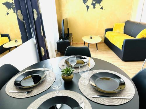 - une table à manger avec des assiettes et des verres à vin dans l'établissement Le Tropical- Beau T2 à 5min du centre-ville, à Annecy