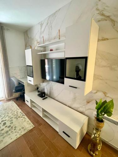 a living room with a white couch and a tv at Apartment Rafailovici in Rafailovici