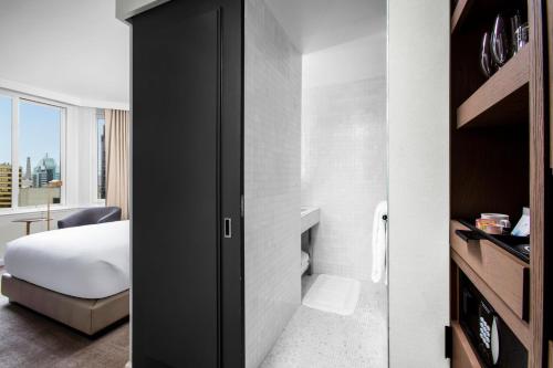 a hotel room with a bed and a bathroom at The Luxury Collection Hotel Manhattan Midtown in New York