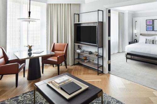 a hotel suite with a bed and a living room at The Luxury Collection Hotel Manhattan Midtown in New York