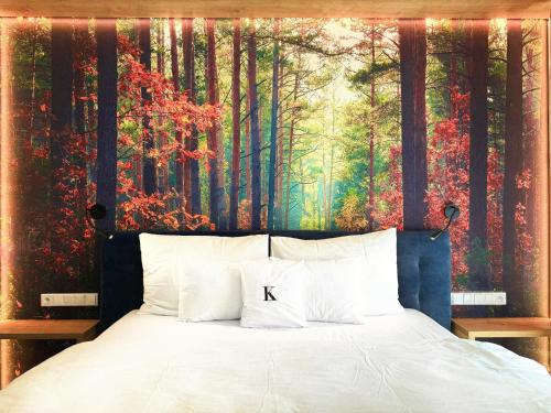 a bedroom with a bed with a painting on the wall at Wellness penzion Lázně Kvilda in Kvilda