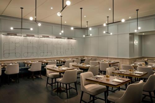 a dining room with tables and chairs and lights at The Luxury Collection Hotel Manhattan Midtown in New York