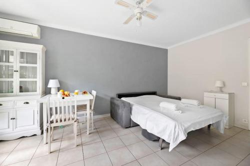 - une chambre avec un lit, une table et un lit bébé dans l'établissement LE LANDELLE - Centre- Climatisation -Proche Gare SNCF, à Menton