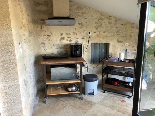 une cuisine avec une table et une cuisinière dans une pièce dans l'établissement Le Pesquier, à Roquemaure