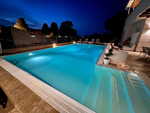 a swimming pool with blue water at night at Kairos Tropea in Tropea