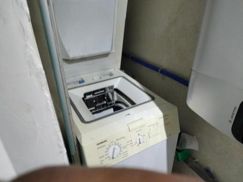 Un lave-linge est installé dans un coin de la pièce. dans l'établissement Agde au 51, à Agde