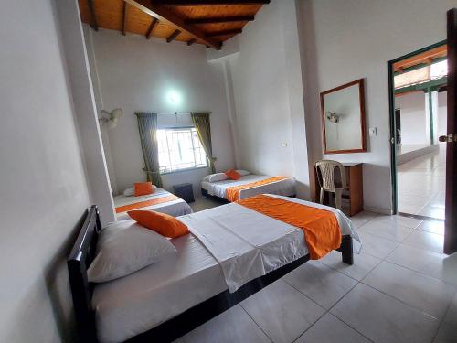 ein Schlafzimmer mit zwei Betten und einem Fenster in der Unterkunft Hotel PARAMO LIDERATO in Paramo
