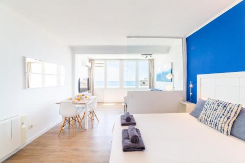 a bedroom with a white bed and a blue wall at Trendy Homes Paradise in Aguadulce
