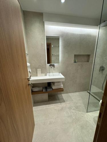 a bathroom with a sink and a glass shower at Studio Nikiti Beach in Nikiti