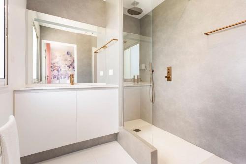 une salle de bain avec une douche avec une porte vitrée dans l'établissement Villa Marebi entre océan et vignes, à Sainte-Hélène