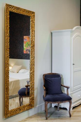 a mirror in a room with a chair and a bed at It's Room Naples in Naples