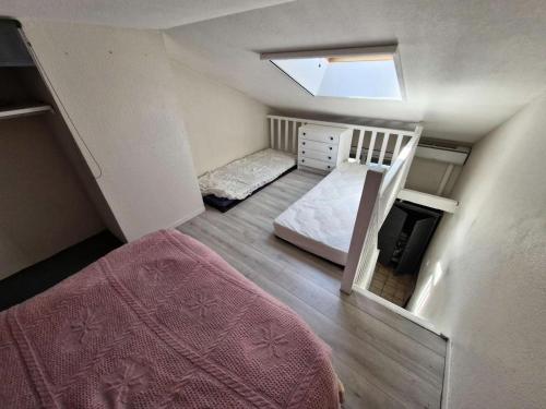 une petite chambre avec un lit et une chambre avec lits superposés avec une échelle dans l'établissement Résidence Hawai 1 - Maisonnette studio mezzanine 4 couchages - PORT LEUCATE MAE-7981, à Leucate
