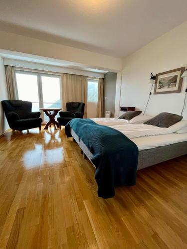 a bedroom with a large bed and two chairs at Hotel Videseter in Stryn