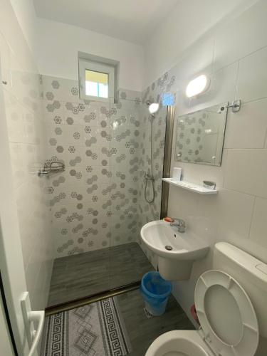 a bathroom with a toilet and a sink and a shower at Casa Andreea in Eforie Sud