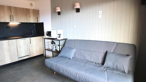 un salon avec un canapé et une cuisine dans l'établissement Résidence Parc Aux Etoiles - A103PAE - APPT T3 AVEC BALCON - 4/6 pers MAE-8634, à Narreyroux