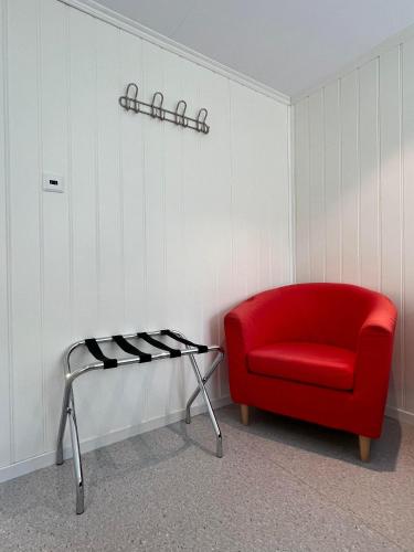 a red chair and a shelf in a room at Hotel Videseter in Stryn