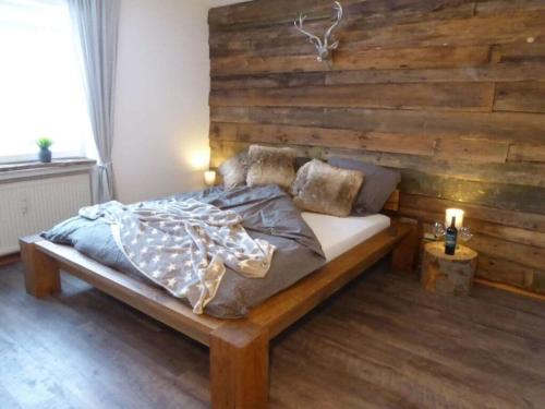 ハーネンクレー・ボックスヴィーゼにあるNice apartment in Hahnenkleeの木製の壁のドミトリールームのベッド1台分です。