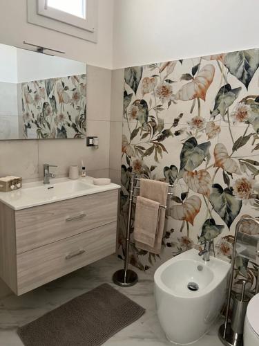 a bathroom with a sink and a toilet and a mirror at Eleutheria in Gravina di Catania
