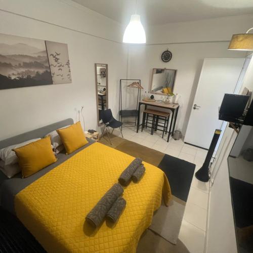 a bedroom with a yellow bed with two slippers on it at Cardia’s Guest House in Sacavém