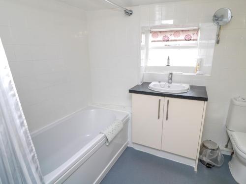 ein Badezimmer mit Badewanne, Waschbecken und Toilette in der Unterkunft White Swan Cottage in Alnwick