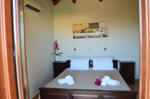 a bedroom with a bed with white towels on it at Julieta Stone Villa in Andip&aacute;ta Er&iacute;sou