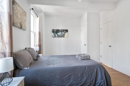 a bedroom with a bed in a white room at Modern Home 4BR 3BA - 20 Min to Timesquare in Jersey City