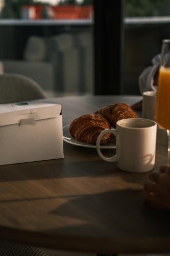 a table with a cup of coffee and a plate of pastries at Hôtel Expérience - Quartier Des Marinas in Magog-Orford