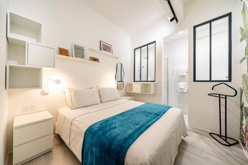 une chambre blanche avec un lit et deux fenêtres dans l'établissement Kazaluka - Appartement au cœur d'Arles, à Arles