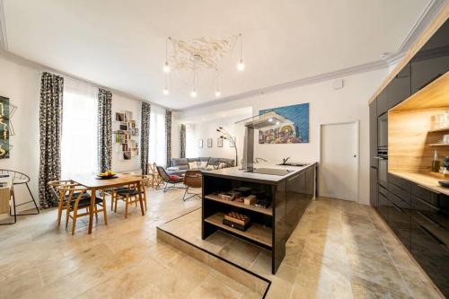 une cuisine et un salon avec un évier et une table dans l'établissement Kazaluka - Appartement au cœur d'Arles, à Arles