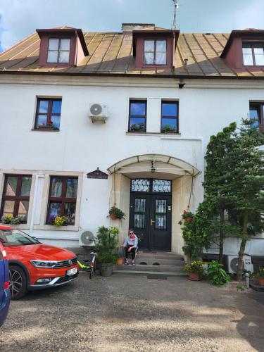 a man sitting on the front door of a house at chatky Pension Doctor in Choustníkovo Hradiště