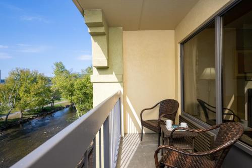 a balcony with two chairs and a view of a river at The Inn On The River in Pigeon Forge