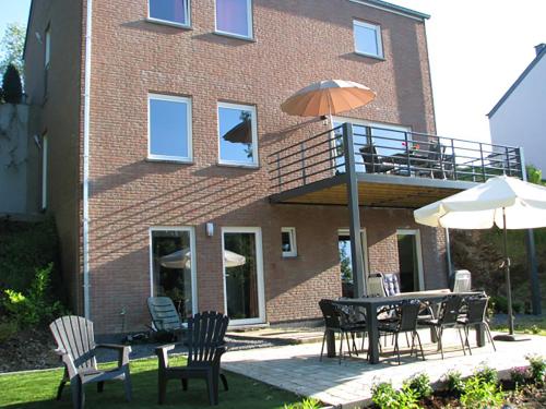a patio with a table and chairs and an umbrella at Holiday Home Pandora in Bouillon