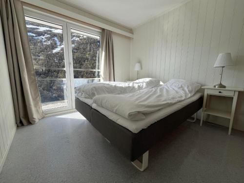 a bedroom with a bed and a large window at Hotel Videseter in Stryn