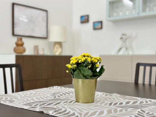 a vase filled with yellow flowers sitting on a table at La Dimora del Corso appartamento in Campi Salentina