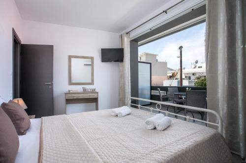 a bedroom with a bed with two towels on it at Maquestas Modern Apartments in Archangelos