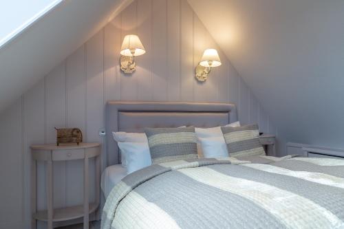 Un dormitorio con una cama y dos luces en la pared. en Weetstich, en Archsum
