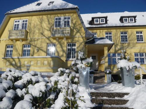 a large yellow house with snow on the ground at Relaxa at a luxurious villa in Bad Pyrmont in Bad Pyrmont