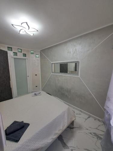 a bedroom with a white bed and a mirror at PRESTIGE House in Nulvi