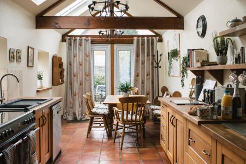 a kitchen with a table and chairs in it at Laurel cottage Melplash in Netherbury