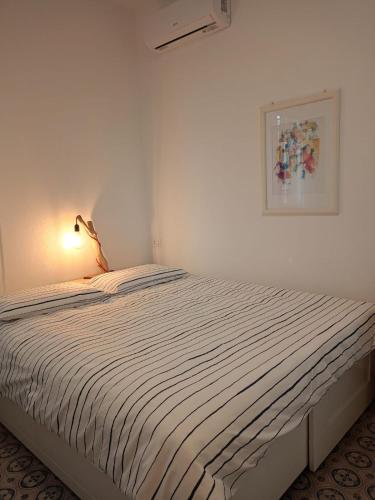a bed in a white room with a picture on the wall at Bblueb&b in Rimini