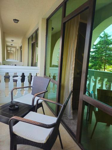 a room with two chairs and a table and a balcony at Art Hotel Babylon in Sunny Beach