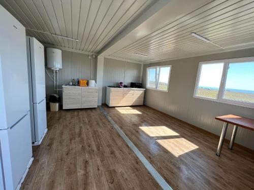 a large room with wooden floors and a room with windows at La Corbu in Corbu