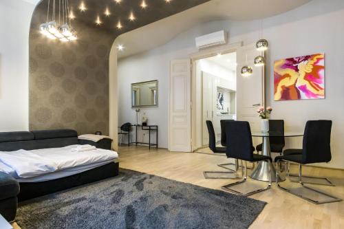 a living room with a bed and a table and chairs at Andrássy Str. Luxury Apartment in Budapest