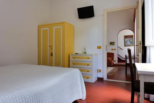 a bedroom with a white bed and a dresser at Hotel Club i Pini - Residenza d'Epoca in Versilia in Lido di Camaiore