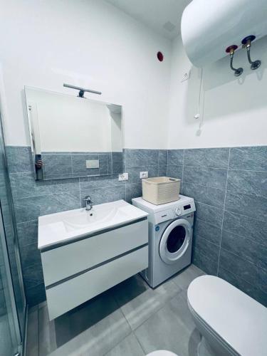 a bathroom with a washing machine and a sink at MK Apartments in Lido di Jesolo