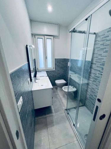 a bathroom with a toilet and a sink and a shower at MK Apartments in Lido di Jesolo