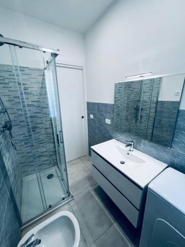 a bathroom with a shower and a sink and a tub at MK Apartments in Lido di Jesolo