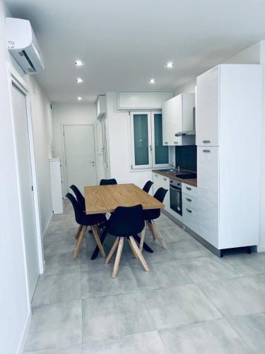 a kitchen with a wooden table and chairs at MK Apartments in Lido di Jesolo