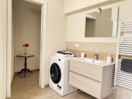 a bathroom with a washing machine and a sink at Monolocale San Guido in Acqui Terme